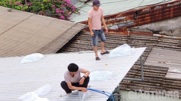 Người dân trên đường Nguyễn Lương Bằng, Liên Chiểu (Đà Nẵng) dùng bao nilon đựng nước để gia cố sức chịu gió cho mái tôn. Ảnh Xuân Huy