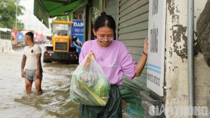 Tranh thủ tạnh mưa, người dân lội nước ra ngoài mua thức ăn