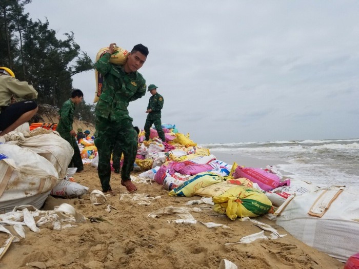 Những bao tải cát lần lượt được vác tới nơi tập kết