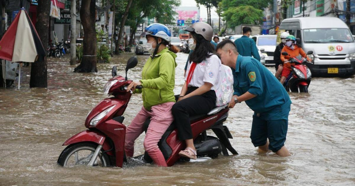 Lực lượng xung kích hỗ trợ phụ huynh đưa con đến trường giữa dòng nước (thời điểm Sở GD&ĐT chưa có chỉ đạo học tại nhà).