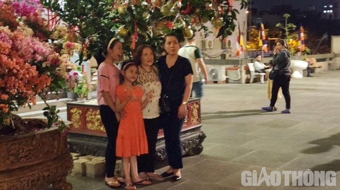Nhiều gia đình sau khi lễ Phật, thư thái đi vãn cảnh chùa và chụp hình lưu niệm