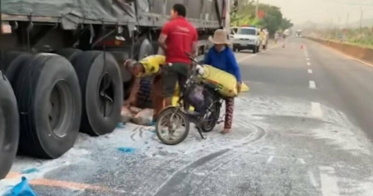 Một số người dân hốt cả bao gạo để chở về sau khi va chạm giữa hai xe làm gạo đổ ra đường. Ảnh cắt từ clip