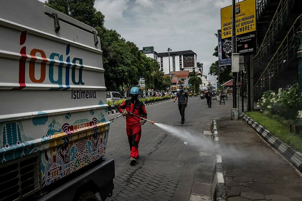 Nhân viên y tế tiêu độc khử trùng trên đường phố Indonesia vào giữa tháng 3. Ảnh: NY Times