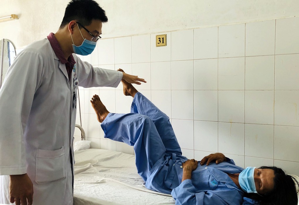 Bệnh nhân Thắng tập cử động hai chân theo y lệnh của bác sĩ. Ảnh: Thanh Phong