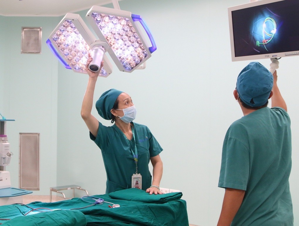 Điều dưỡng Thủy có 33 năm kinh nghiệm điều dưỡng phòng mổ. Chị cùng kỹ thuật viên kiểm tra thiết bị trước khi xông phòng, chiếu tia UV. Ảnh Thư Anh.