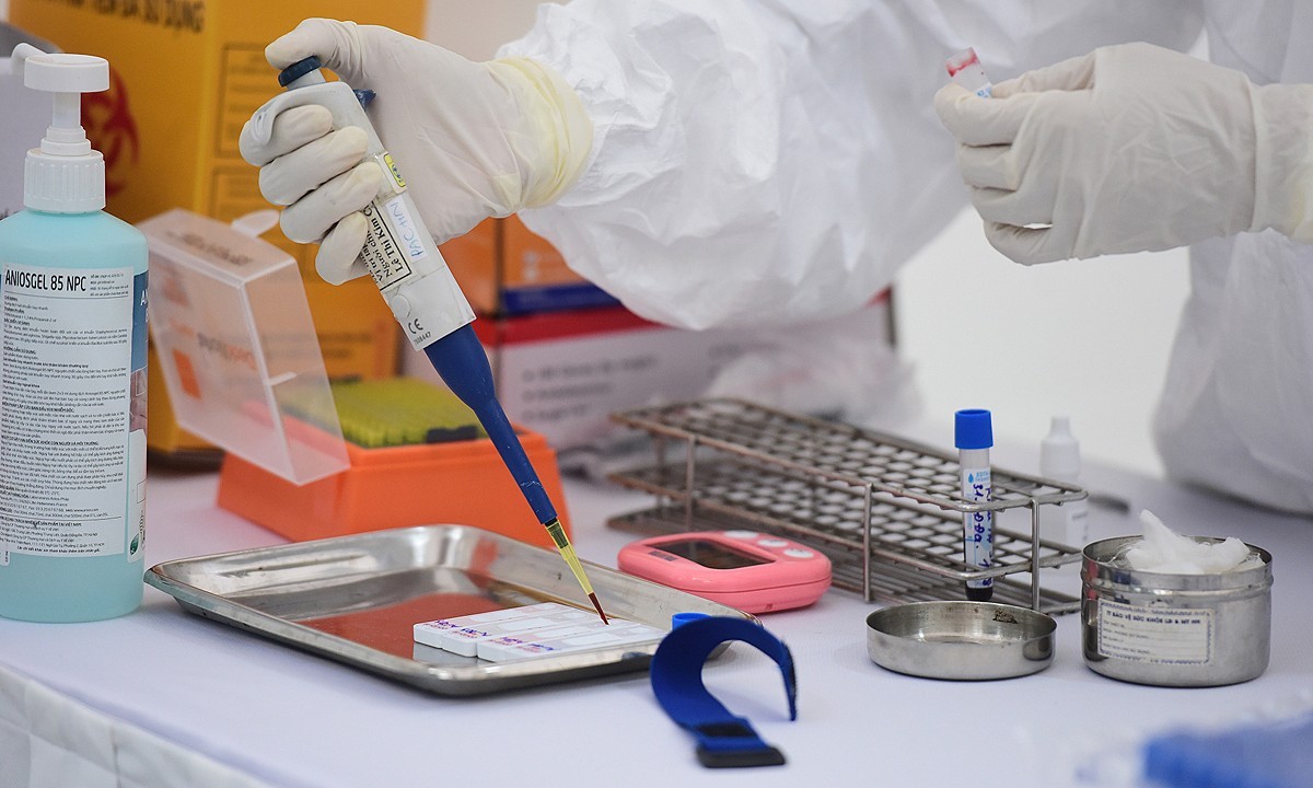 A medic works on samples taken for testing the new coronavirus infection in Hanoi, April, 2020. Photo by VnExpress/Ngoc Thanh.