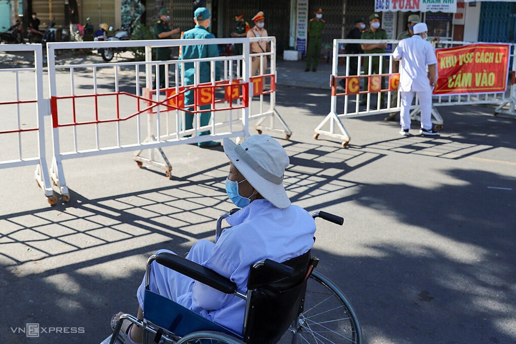 Một bệnh nhân chạy thận chờ được vào bệnh viện bên ngoài gác chắn cách ly. Ảnh: Nguyễn Đông.