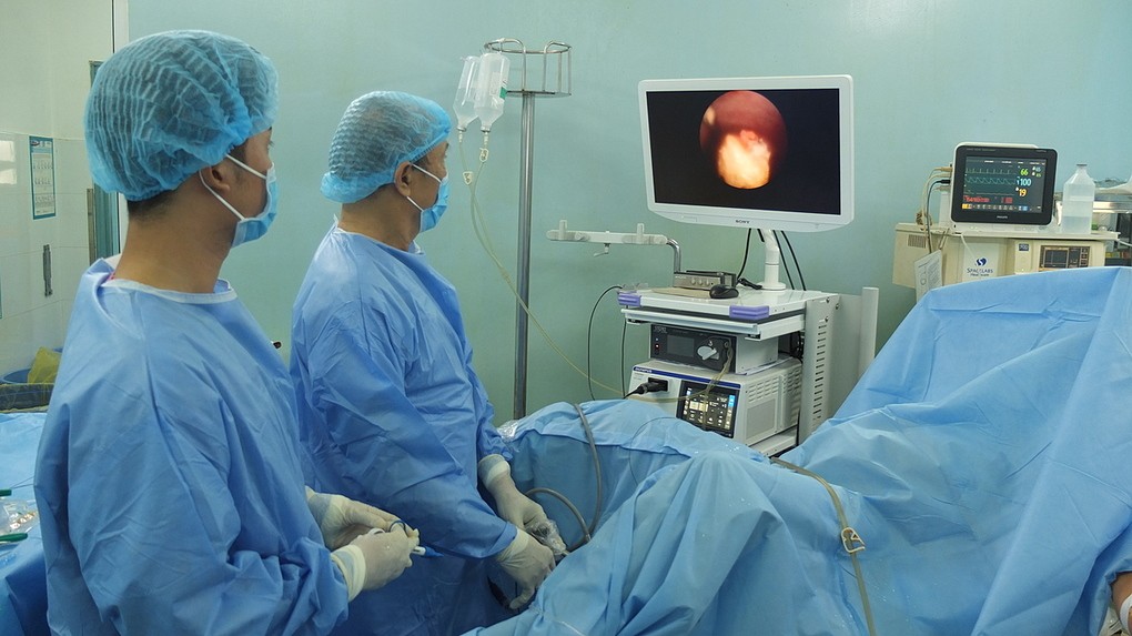 Phó giáo sư Vũ Lê Chuyên trực tiếp nội soi tán sỏi bàng quang bằng laser cho nam bệnh nhân. Ảnh: Trần Nhung.