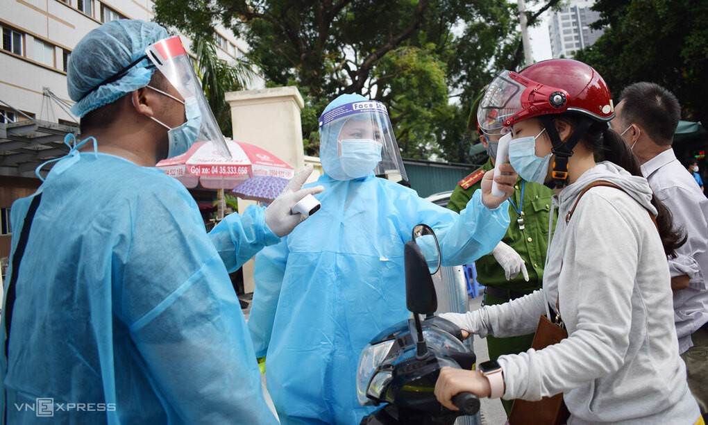 Đo nhiệt độ nhân viên y tế vào làm việc và cách ly tại Bệnh viện E sáng 20/8. Ảnh: Chi Lê.