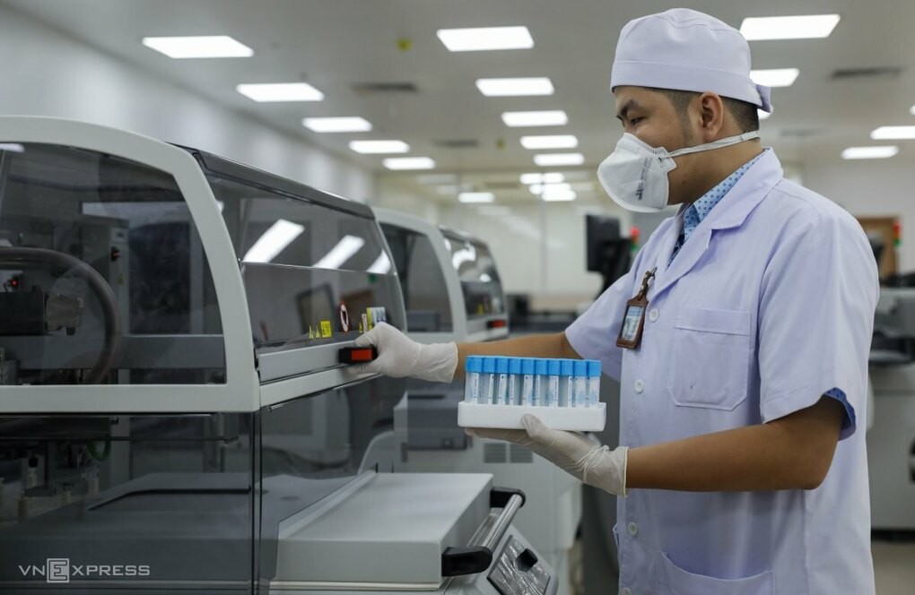 Kỹ thuật viên thao tác trên hệ thống máy xét nghiệm sinh hóa và miễn dịch hiện đại nhất, công suất 3.600 mẫu một giờ, hoàn toàn tự động và hoạt động liên tục 24/7. Ảnh: Quỳnh Trần.