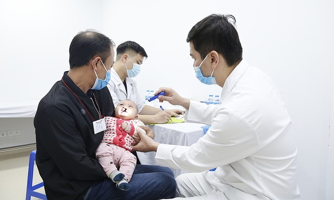 Một em bé dị tật vòm miệng được khám sàng lọc sáng 14/12. Ảnh: Đức Thuấn.
