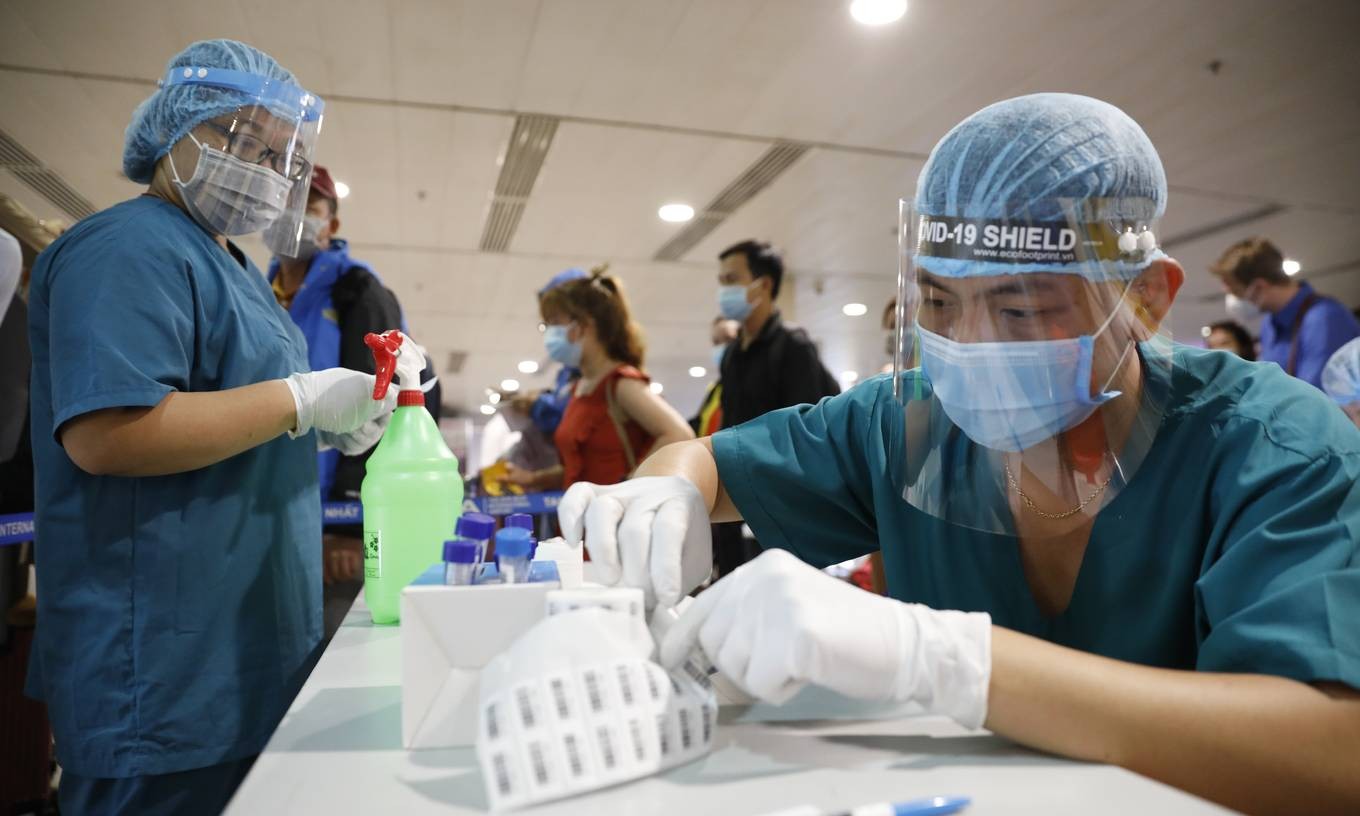 Medical workers collect samples for Covid-19 testing at HCMC&amp;amp;#039;s Tan Son Nhat Airport, May 6, 2021. Photo by VnExpress/Huu Khoa.