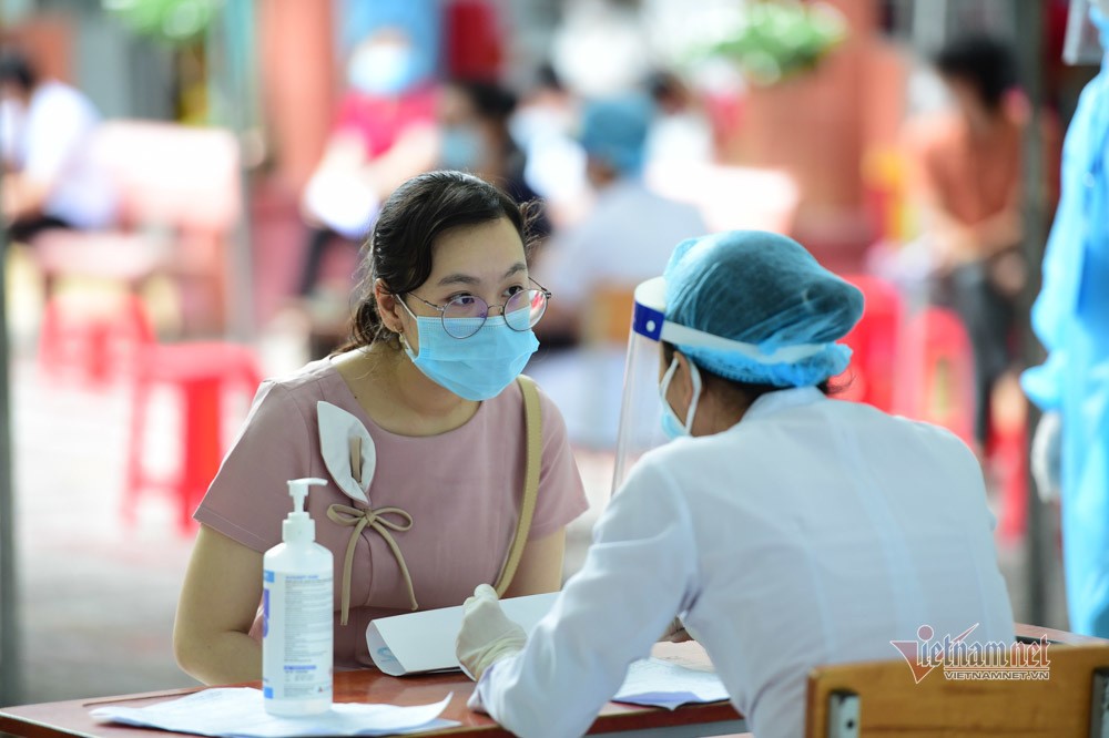 Một người dân tại TP.HCM nghe nhân viên y tế tư vấn khi tiêm vắc xin Covid-19. Ảnh: Thành Tùng.