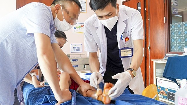 Bác sĩ xử trí vết thương cho bé bị tai nạn cửa trượt tự động.