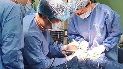 Các bác sĩ phẫu thuật cấy ốc tai điện tử cho trẻ.