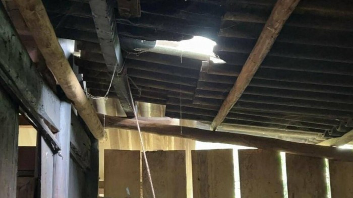 Một nhà dân ở gần bị đá rơi hỏng mái che (Ảnh BNA)