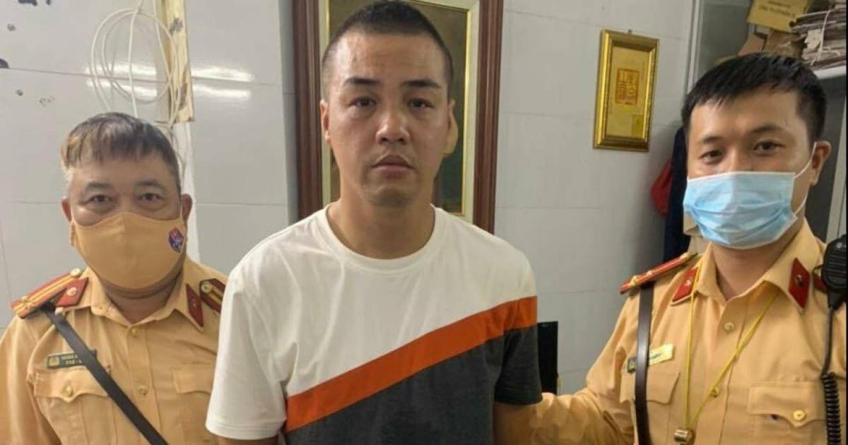 Tên cướp (giữa ảnh) tại trụ sở công an