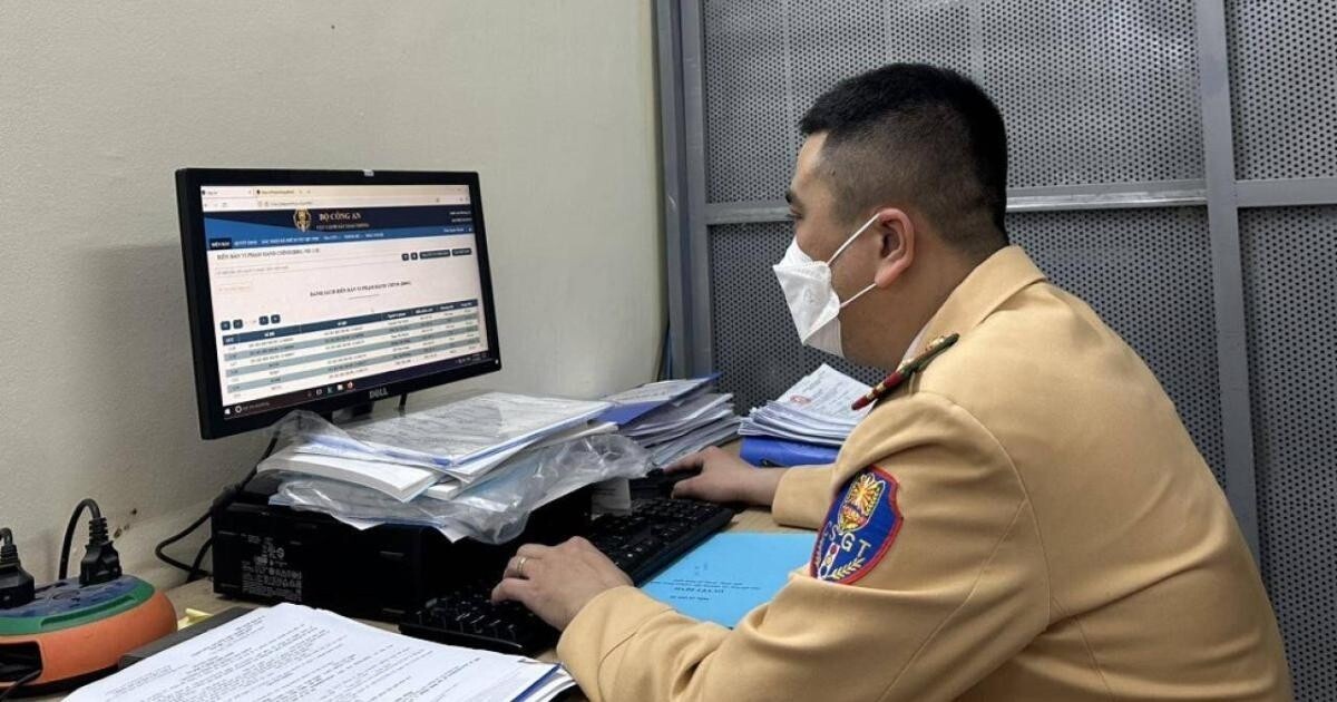 Cán bộ CSGT đang thực hiện tra cứu thông tin phục vụ người dân thực hiện nộp phạt nguội vi phạm giao thông tại nơi cư trú